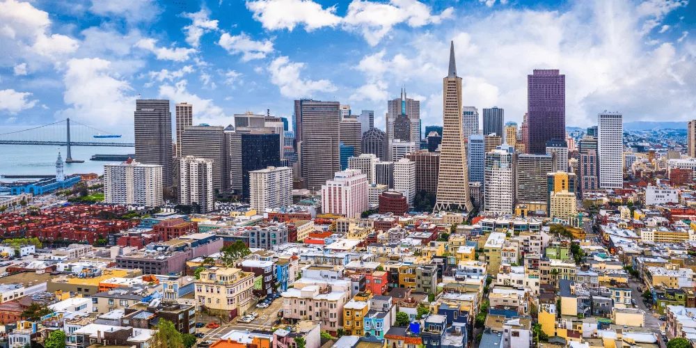 An aerial view of San Francisco with the bay bridge in the background