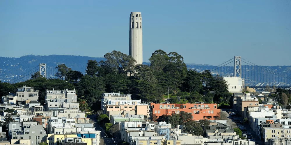 coit tower view with bay bridge on the background