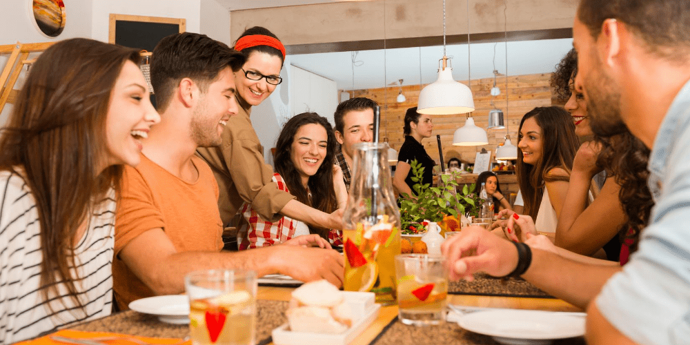 a group of people laughing during their lunch