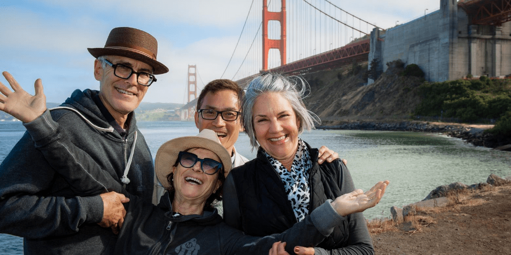 people posing in front of the golden gate bridge