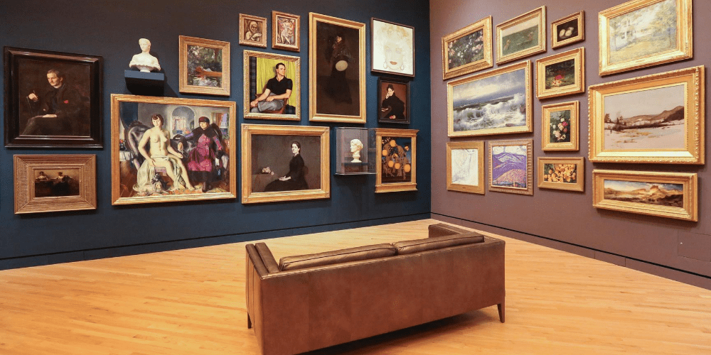 a couch standing in the middle of room full of paintings