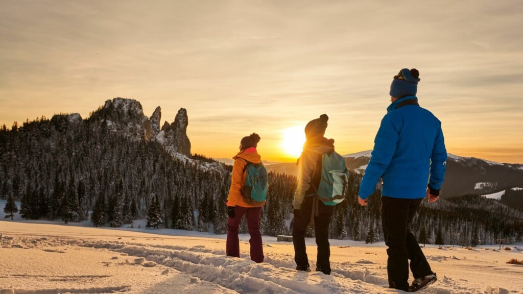 group go people with backpacks hiking during winter