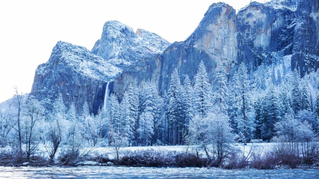 A view of the snow-covered mountains and trees in Yosemite Valley.