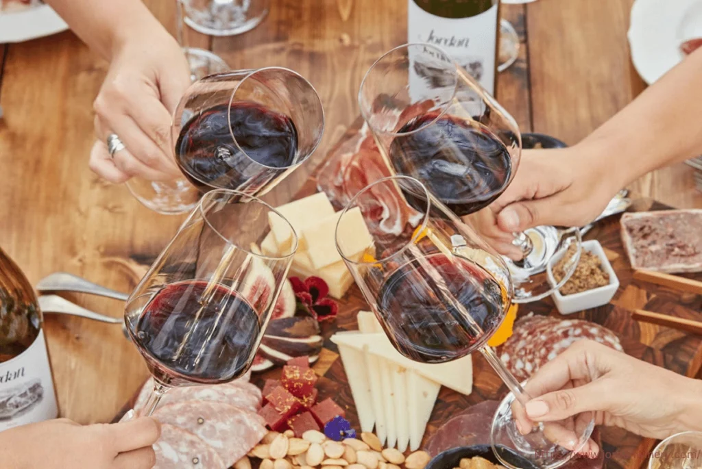 people toasting with glasses of red wine