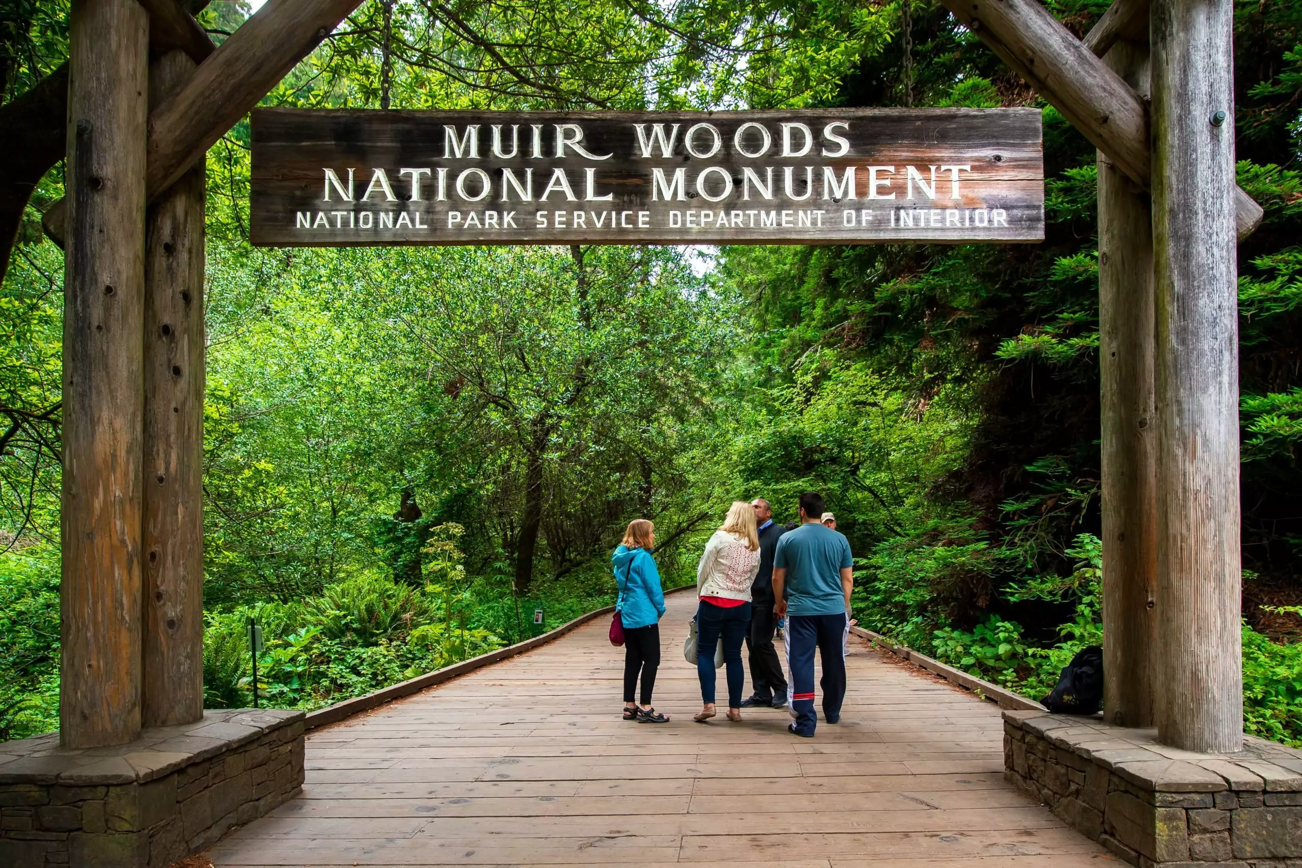 people standing in front of the entrance to muir woods