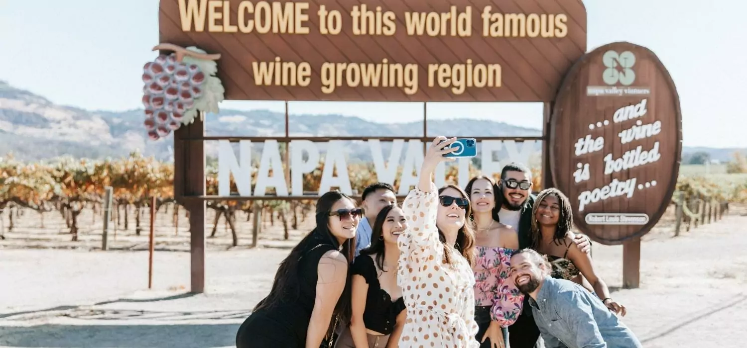 people taking selfie in front of Napa Valley welcome sign