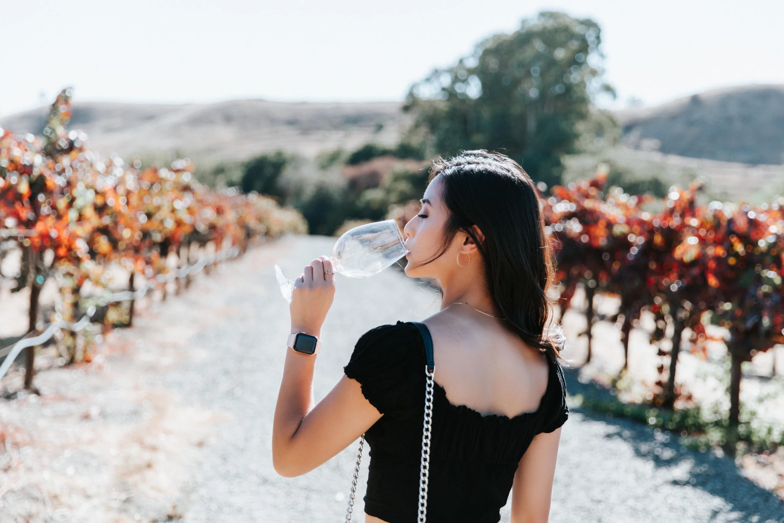 girl drinking wine in the vineyards