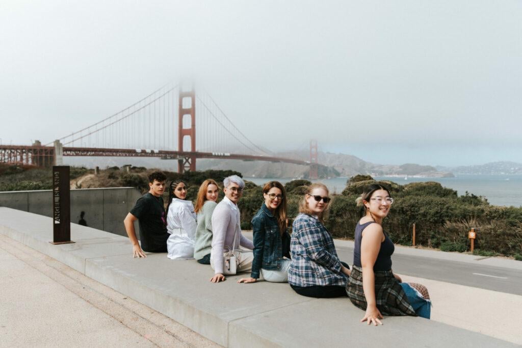 people sitting on the bench, golden gate bridge on the background