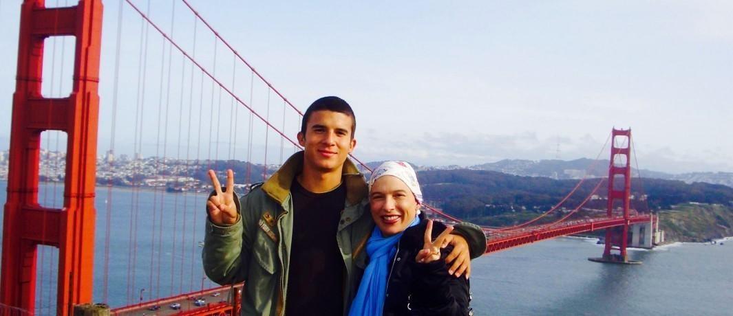 people showing peace sign and posing in front of the Golden Gate Bridge