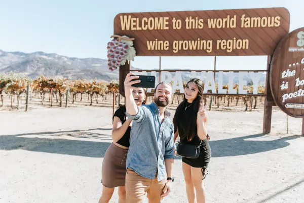 group of people taking a picture in front of the welcome napa sign