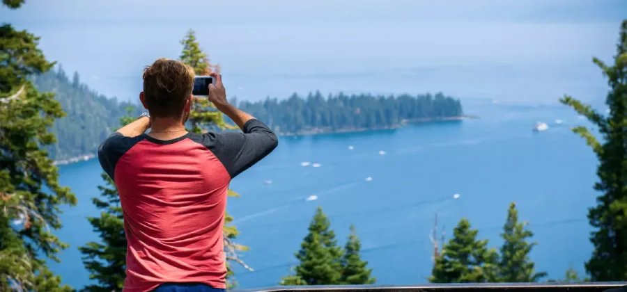 man taking a photo of lake tahoe