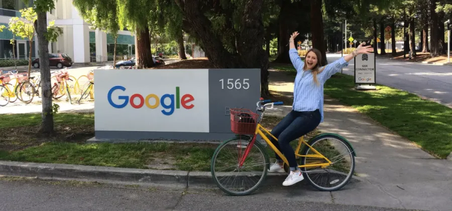 woman riding a bike in front of a signage