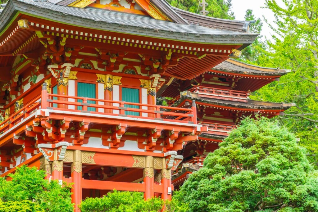 a red structured Japanese tea garden surrounded by trees 