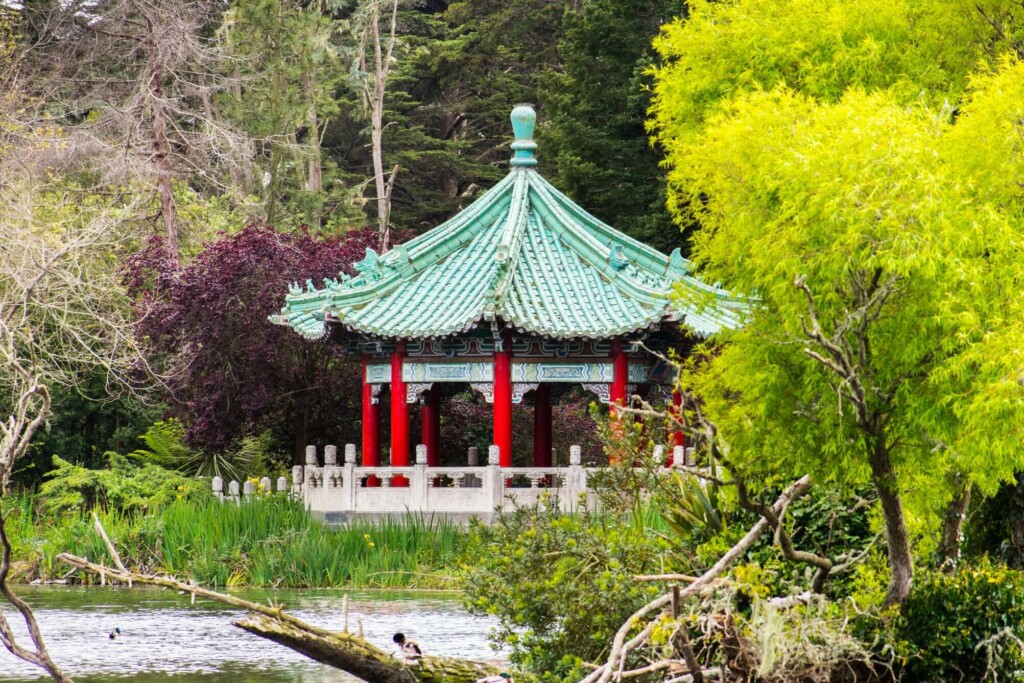 a pagoda surrounded by trees and a lake 