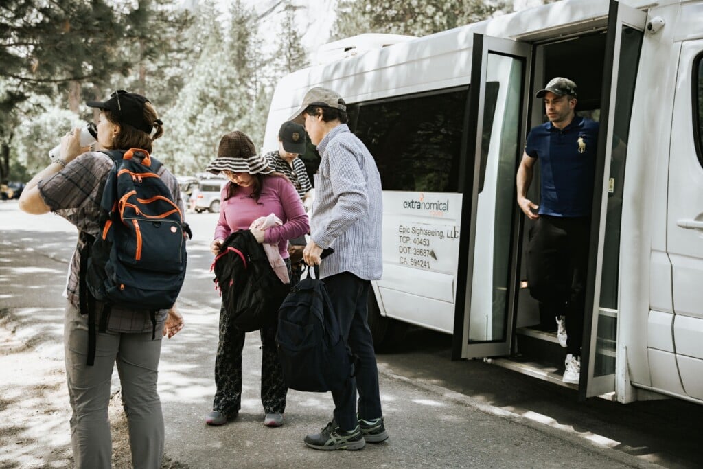 a group of tourists offboarding extranomical bus in yosemite