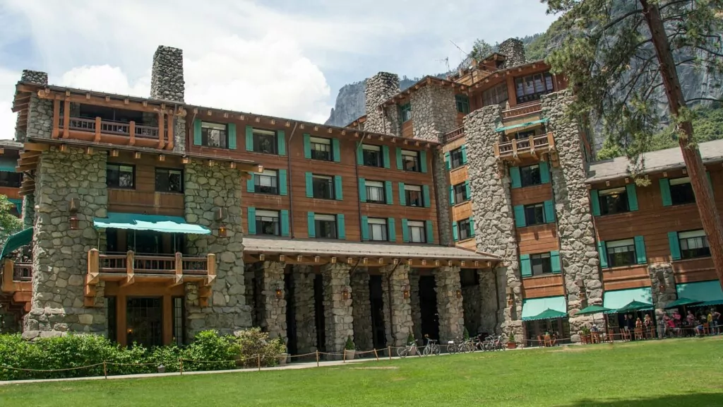 a group of tourists eating at a restaurant in the Ahwahnee Hotel building