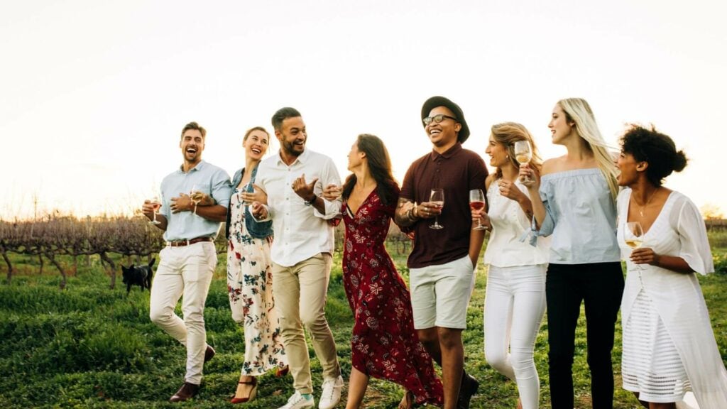 a group of people smiling with glasses of wine in hand 