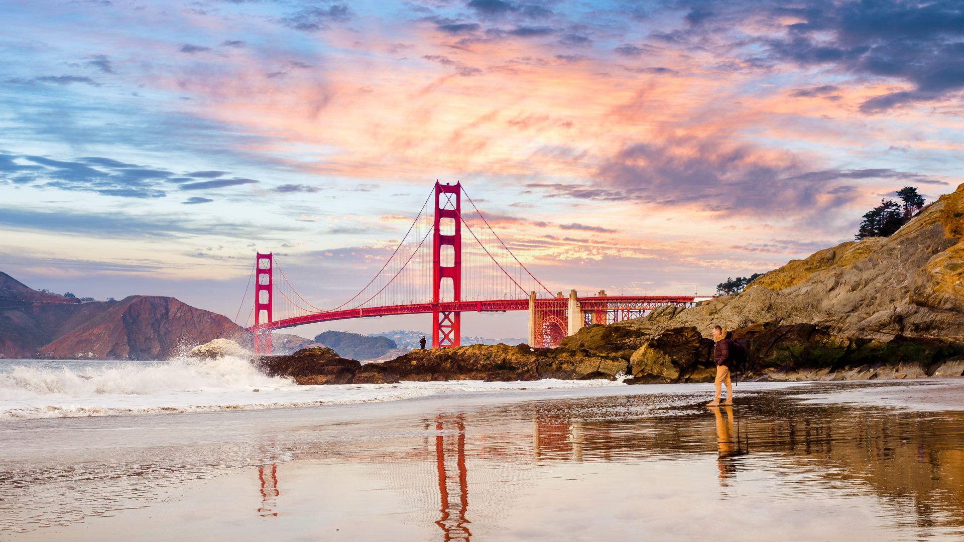 a view of golden gate bridge with purple and pink skied in the background during the fall in San Francisco