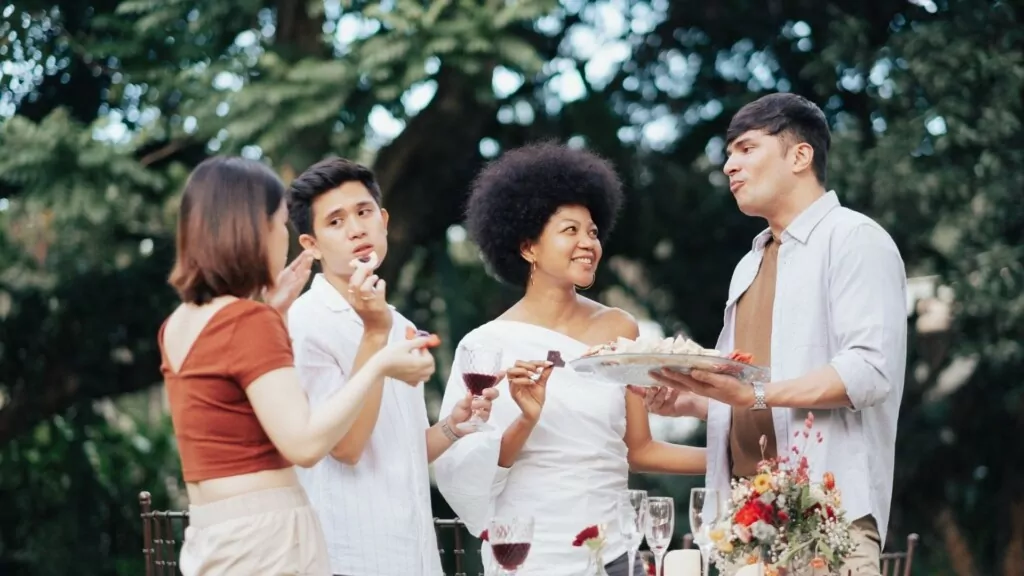 group of smiling people holding glasses of red wine in California wine country