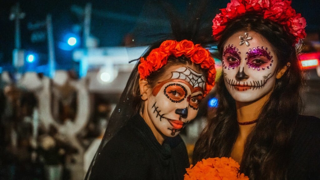 a photo of 2 women with face painting for a Halloween festival 