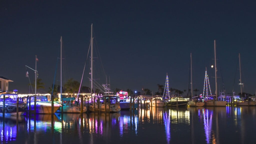 boats decorated with lights lined up by the bay