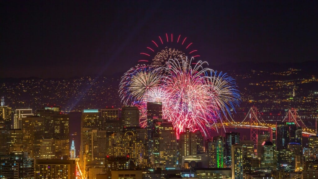 colorful fireworks surrounded by san francisco city lights