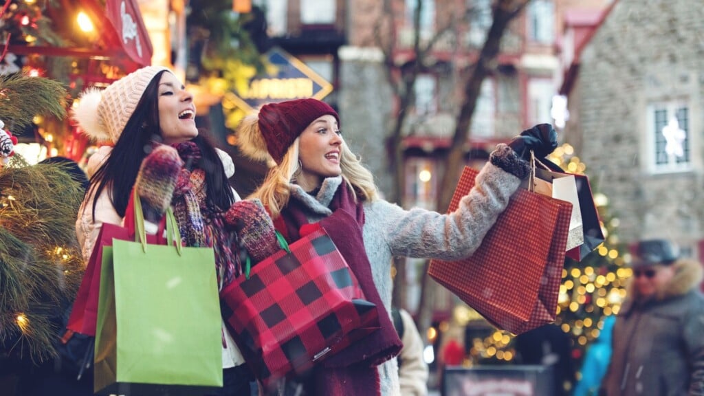 two women shopping with with Chrismas bags in hand 