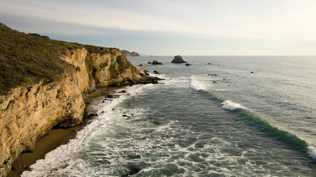 blue ocean waves crashing by the shore 