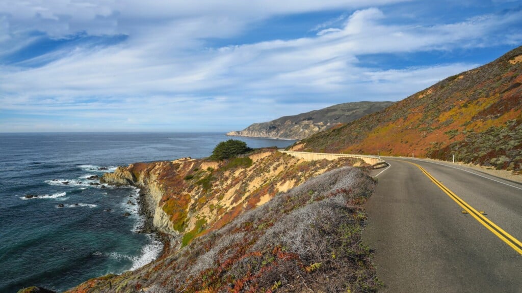 photo of a roadway beside a coast
