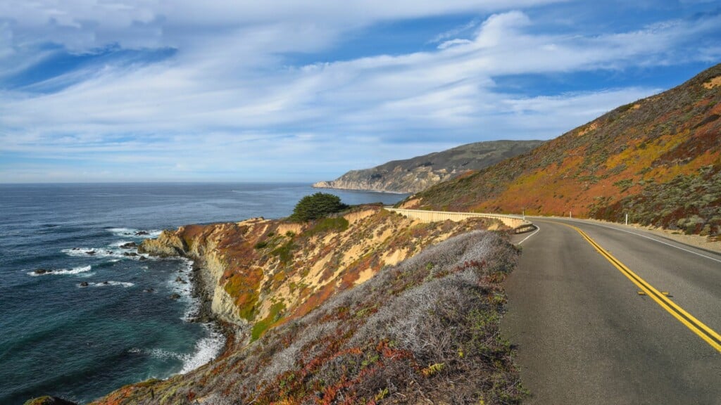 photo of a roadway beside a coast 