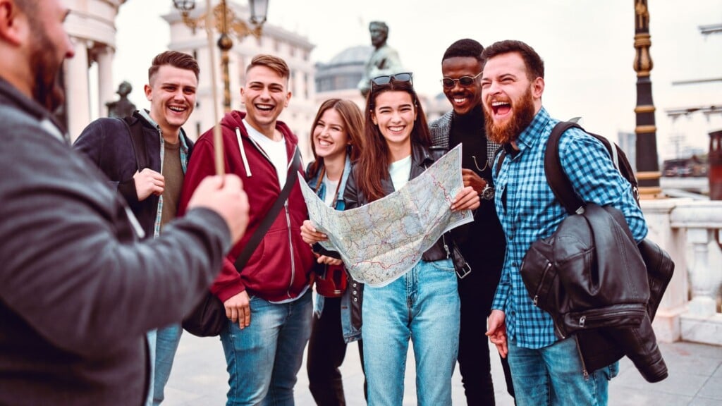 a smiling woman in a black jacket holding a map 