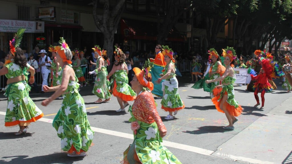 group of people in a green dress dancing at a parade 