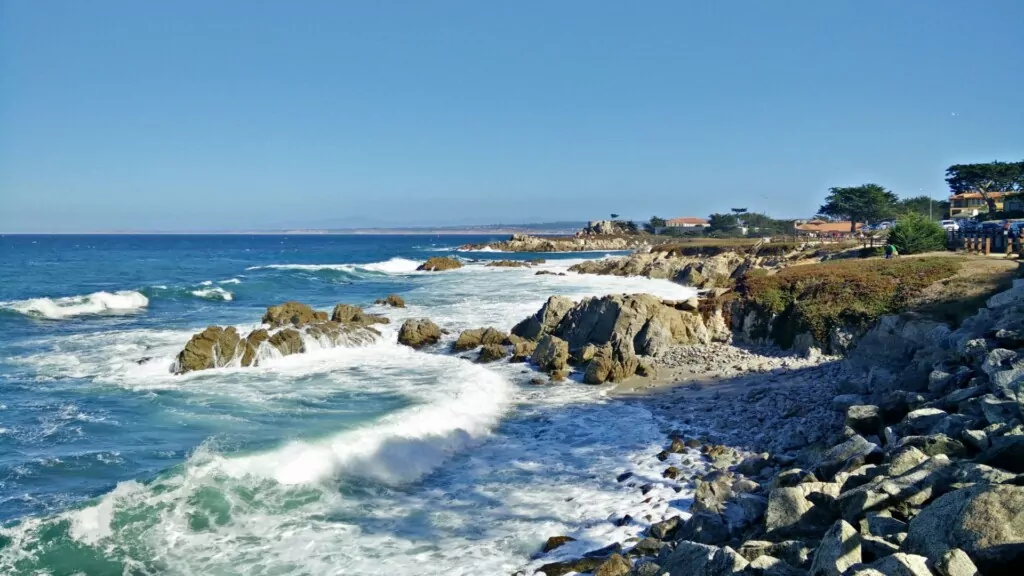 A scenic coastal view with waves crashing against rocky shores.